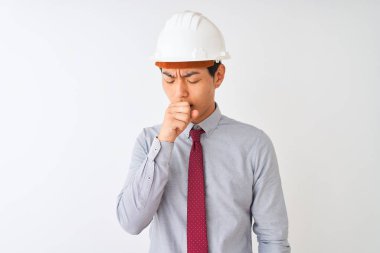 Kravat ve kask takan Çinli mimar soğuk algınlığı veya bronşitin belirtisi olarak kendini kötü hissedip öksürüyor. Sağlık hizmetleri kavramı.