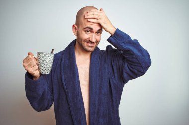 Sabahları bornoz giyen genç bir adam izole edilmiş arka planda bir fincan kahve içerken el ele, utanç ve şaşkınlık dolu, sinirli ve hayal kırıklığına uğramış bir şekilde strese girdi. Hata için korku ve üzüntü.