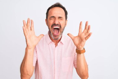 Orta yaşlı, pembe tişörtlü yakışıklı bir adam izole edilmiş beyaz arka planda duruyor. Başarılı olmak için çılgın ve çılgın bir kutlama yapıyorlar. Kolları havada ve gözleri kapalı, heyecanlı bir şekilde çığlık atıyorlar. Kazanan konsept