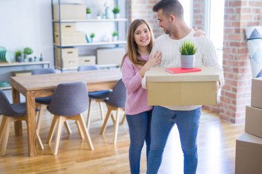 Yeni ev, yeni bir daire için çok mutlu ve neşeli karton kutular tutarak hareket aşk genç güzel çift