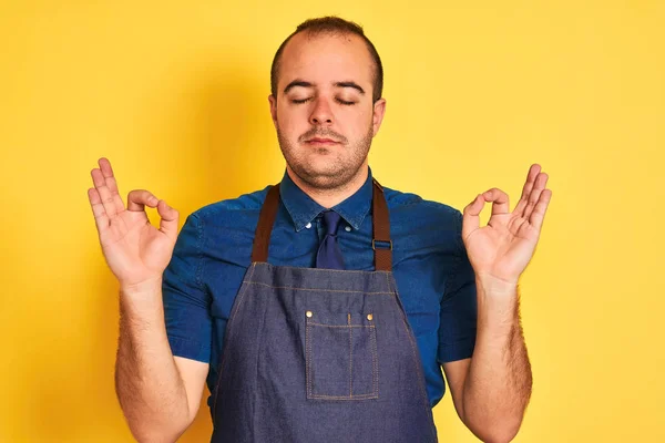 Young Shopkeeper Man Wearing Apron Standing Isolated Yellow Background Relax — Stock Photo, Image