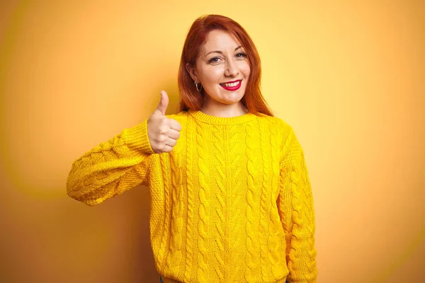 Piękna Ruda Kobieta Ubrana Zimowy Sweter Stojąca Nad Odizolowanym Żółtym — Zdjęcie stockowe
