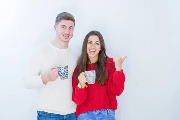 Casal Jovem Bonito Sobre Fundo Isolado Branco Bebendo Uma Xícara — Fotografia de Stock