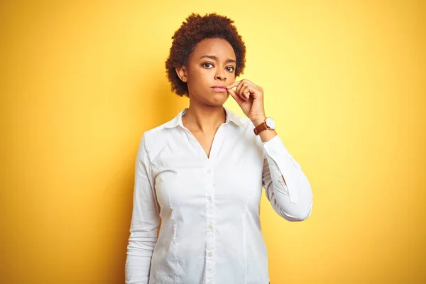 African american business woman over isolated yellow background mouth and lips shut as zip with fingers. Secret and silent, taboo talking