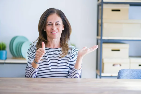 Mujer Mayor Mediana Edad Sentada Mesa Casa Mostrando Palma Mano —  Fotos de Stock