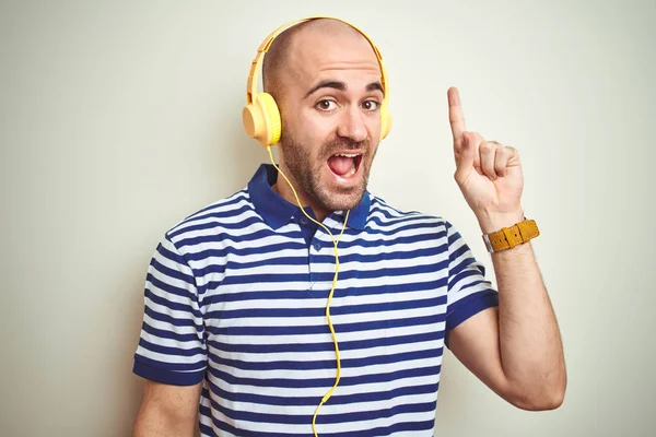 Jovem Ouvindo Música Usando Fones Ouvido Amarelos Sobre Fundo Isolado — Fotografia de Stock