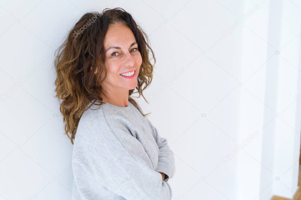 Beautiful middle age woman with curly hair smiling cheerful and 