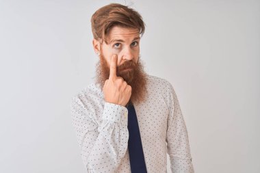 Genç kızıl saçlı İrlandalı işadamı, izole edilmiş beyaz arka planda duruyor. Gözünü dikip jestini izliyor. Şüpheli bir ifade.