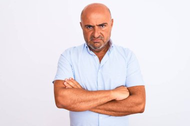 İzole edilmiş beyaz arka planda duran, kuşkucu ve gergin orta yaşlı, yakışıklı bir adam. Yüzünde çapraz kollarla onaylamayan bir ifade var. Negatif kişi.