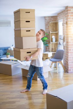 Evde kutuları olan bir adam.