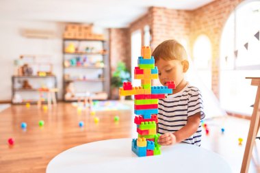 Güzel çocuk anaokulunda inşaat bloklarıyla oynuyor.