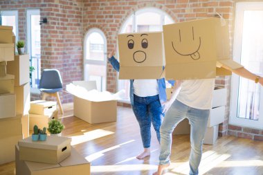 Komik emoji ile karton kutular giyen çılgın çift kafa üzerinde yüzler, yeni evde eğlenmek