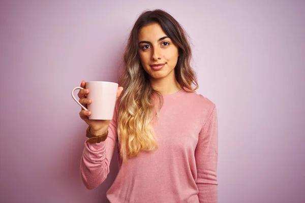 Νεαρή Όμορφη Γυναίκα Κρατώντας Φλιτζάνι Καφέ Πάνω Από Ροζ Απομονωμένο — Φωτογραφία Αρχείου