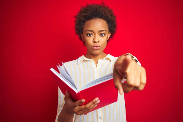 Afrikansk Amerikansk Kvinna Läser Bok Över Röd Isolerad Bakgrund Pekar — Stockfoto