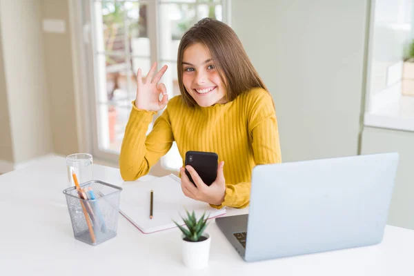 Hermosa Niña Usando Teléfono Inteligente Computadora Portátil Haciendo Signo Con —  Fotos de Stock