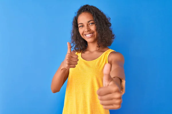 티셔츠를 고립된 위에서 손으로 긍정적 행동을 승인하는 브라질 여성이 웃으며 — 스톡 사진
