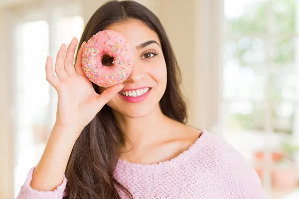 目にピンクのドーナツを見て笑っている美しい若い女性 — ストック写真