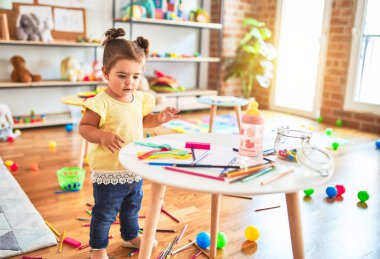 Anaokulunun masasında oyuncaklarla oynayan güzel çocuk.