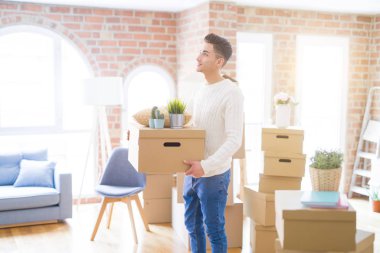 Genç adam, yeni bir eve hareket mutlu holdig karton kutu gülümseyen