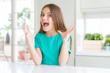 Güzel genç kız çocuk giyen yeşil t-shirt deli ve çığlık kaldırdı ve açık gözleri heyecanlı silah ile başarı için hayran kutluyor. Kazanan kavramı