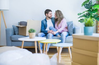 Genç çift içinde aşk sarılma oturma üzerinde the kanepe çok mutlu Moving için bir yeni ev