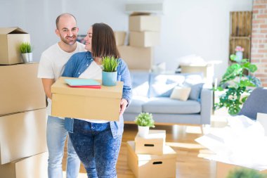 Genç çift yeni bir eve hareket, mutlu tutan karton kutular gülümseyen