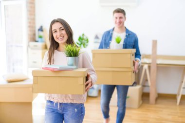 Güzel genç çift yeni bir eve taşınmayı kutlarken gülümsüyor.