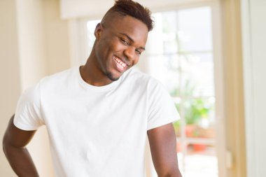 Gülümseyen yüzünde kocaman bir gülümseme ile neşeli Afrika yakışıklı genç