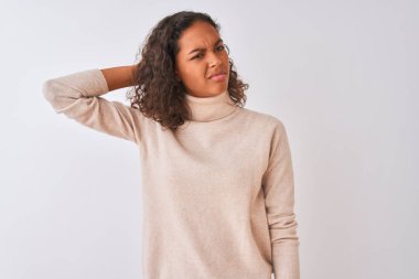 Balıkçı yaka kazak giyen genç Brezilyalı kadın izole edilmiş beyaz arka planda duruyor. Soruyu merak ediyor. Şüpheyle kararsız, kafa kafaya düşünerek. Düşünceli kavram.