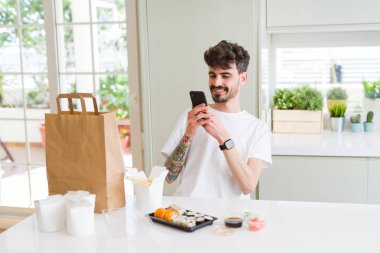 Genç adam alma fotoğraf ile Smartphone arasında Suşi Asya gıda fr