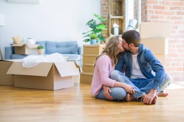 Yeni bir eve taşımak için etrafında karton kutular ile birlikte katta oturan aşk genç güzel çift