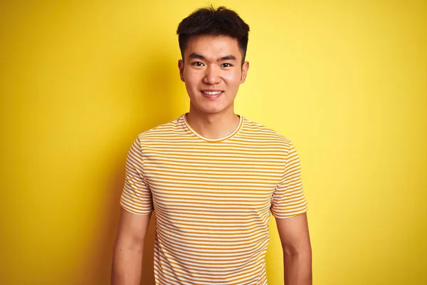 若いアジア系中国人男性のTシャツを着て 幸せとクールな笑顔で孤立した黄色の背景の上に立っている 運のいい人 — ストック写真
