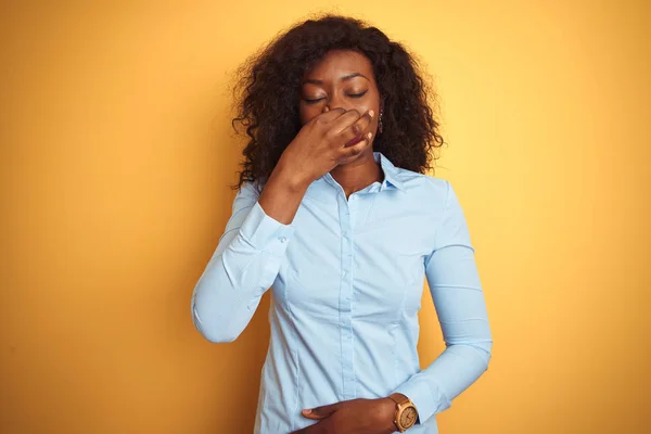 アフリカ系アメリカ人の実業家は 孤立した黄色の背景の上にエレガントなシャツを着て 鼻の上に指で息を保持し 臭いと嫌な 耐え難い匂い何かを嗅ぐ 悪い匂いの概念 — ストック写真