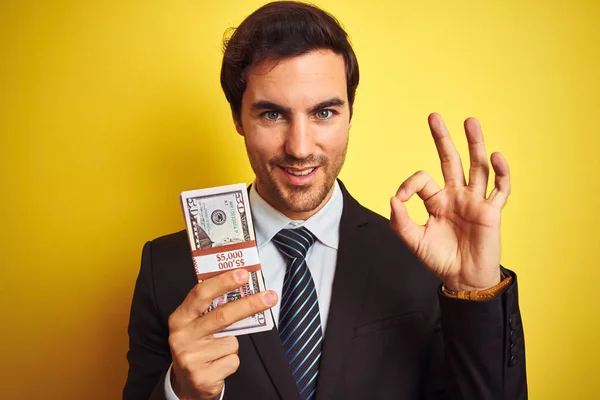 Jovem Empresário Bonito Vestindo Terno Segurando Dólares Sobre Fundo Amarelo — Fotografia de Stock