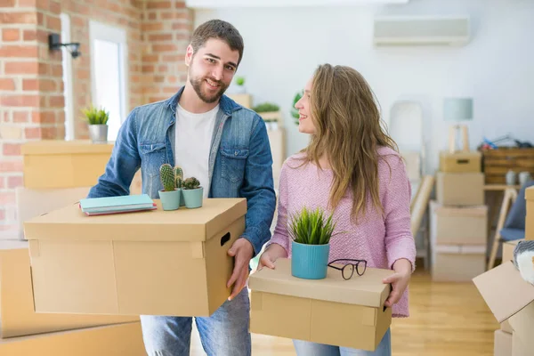 Yeni bir ev taşımak karton kutular tutarak birlikte çok mutlu genç güzel çift