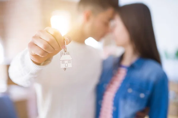 Young asian couple holding keys of new house, smiling happy and excited moving to a new apartment