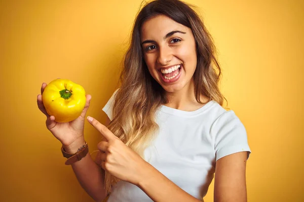 Joven Hermosa Mujer Sosteniendo Pimienta Sobre Fondo Aislado Amarillo Muy —  Fotos de Stock