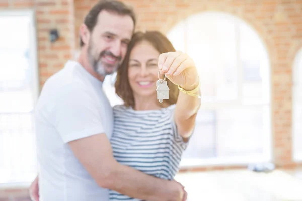 Moyen âge couple romantique senior tenant et montrant les clés de la maison — Photo