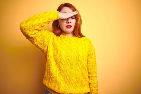 美丽的红头发女人穿着冬季毛衣站在孤立的黄色背景上 用手捂住眼睛 看起来严肃而忧郁 目光短浅 躲藏和拒绝的概念 — 图库照片