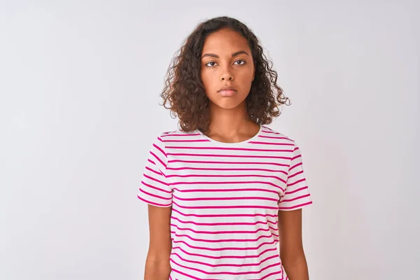 年轻的巴西女人穿着粉色条纹T恤 站在孤立的白色背景上 脸上带着严肃的表情 简单而自然地看着相机 — 图库照片