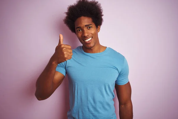 黑头发的非裔美国人穿着蓝色T恤 站在孤立的粉色背景上 手举着快乐的大拇指 在镜头前看着成功的表情 — 图库照片