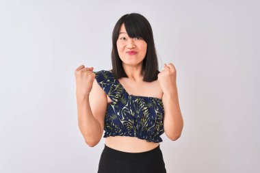 Yazlık çiçekli tişört giyen genç, güzel Çinli bir kadın izole edilmiş beyaz arka plan üzerine şaşırmış ve şaşırmış bir şekilde kollarını kaldırıp, gözlerini açarak başarıyı kutluyor. Kazanan konsept.