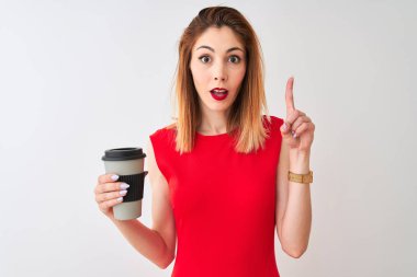 Genç, güzel, kızıl saçlı bir kadın izole edilmiş beyaz arka planda kahve içerken bir fikir ya da soru işareti ile şaşırdı.