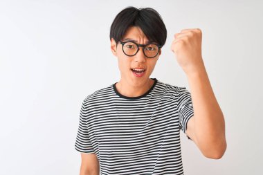 Gözlüklü ve donanma tişörtlü Çinli bir adam izole edilmiş beyaz arka planda öfkeli ve kızgın duruyor öfkeyle bağırırken yumruğunu kaldırıyor. Öfke ve agresif kavram.