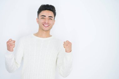 Beyaz tenli yakışıklı genç adam kollarını kaldırıp, gözlerini açarak başarıyı kutluyor ve şaşırıyor. Kazanan konsept.