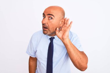 Orta yaşlı işadamı, izole edilmiş beyaz arka planda dikilen kravat takıyor. Kulağından kulağa gülümsüyor ve dedikoduları dinliyor. Sağırlık kavramı.