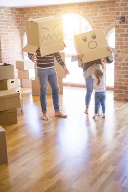 Yeni evde karton bel kutuları ile oynayan çocuk ile güzel famiily