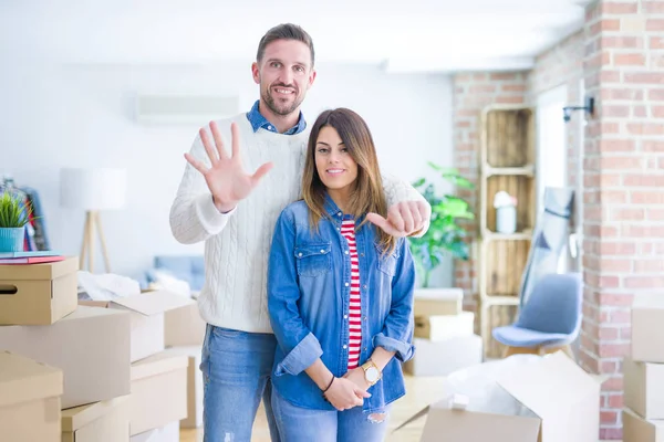 Jovem Casal Bonito Casa Nova Torno Caixas Papelão Mostrando Apontando — Fotografia de Stock