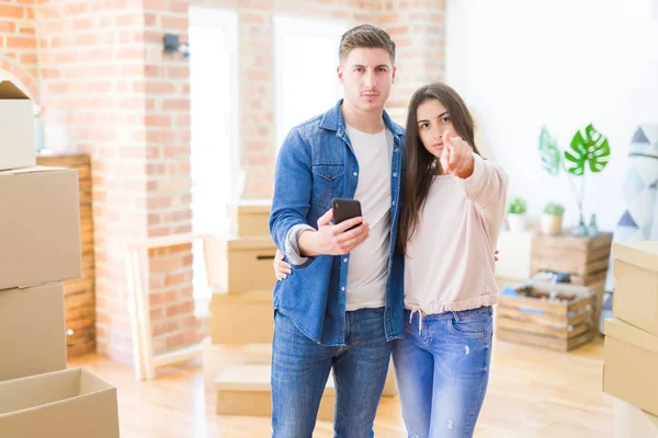 Belo Jovem Casal Mudando Para Uma Nova Casa Usando Smartphone — Fotografia de Stock