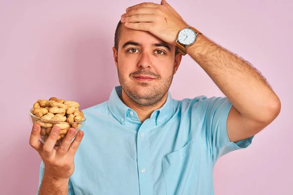 Jongeman Met Een Schaal Vol Pinda Die Een Geïsoleerde Roze — Stockfoto